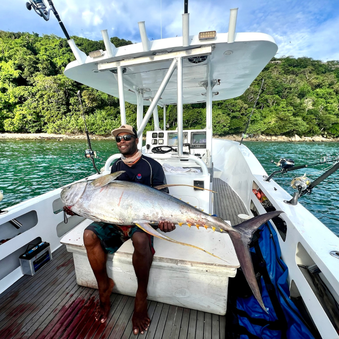 Man holding yellow fin tuna from trolling fishing technique