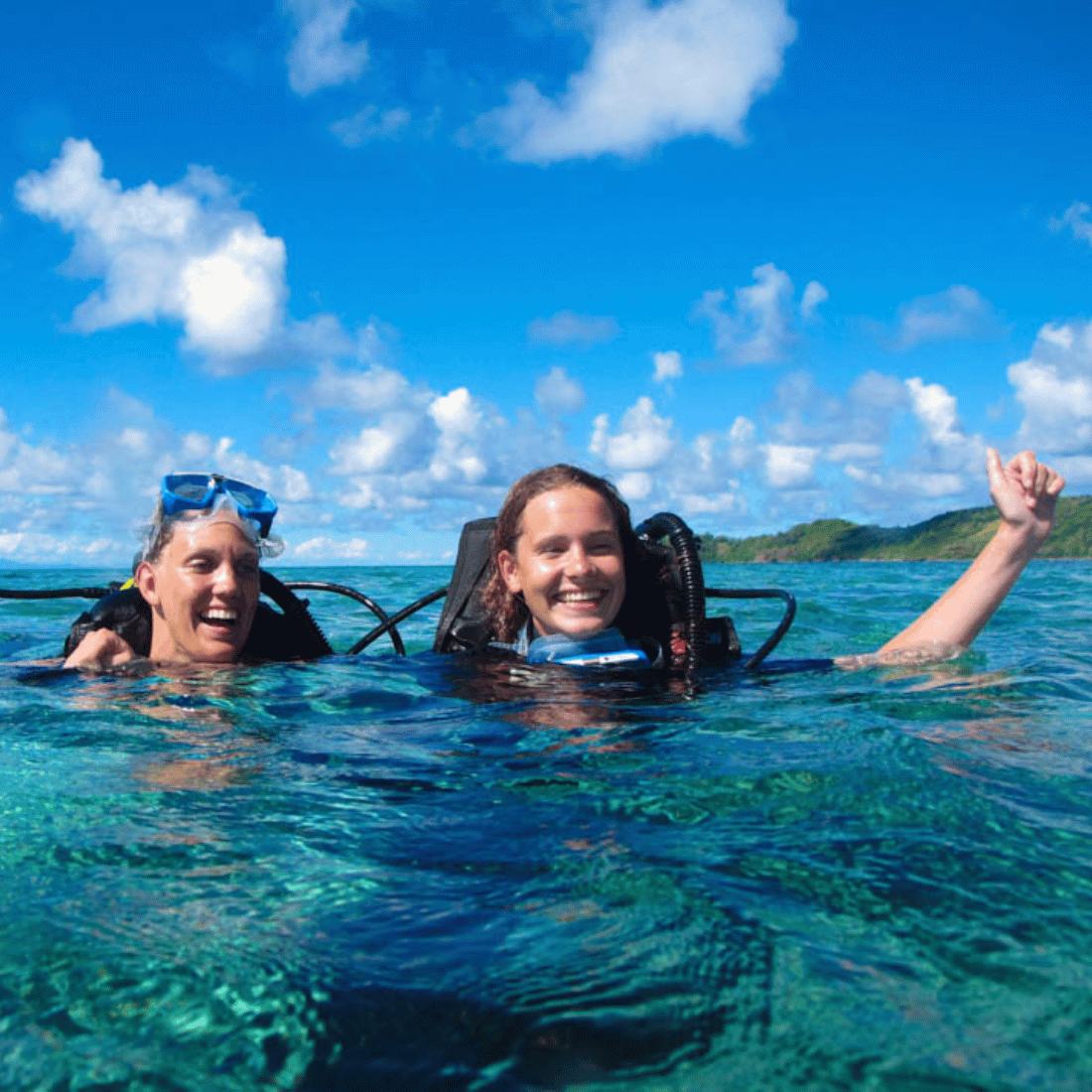 Friends diving into the turquoise waters from their yacht hire in Fiji