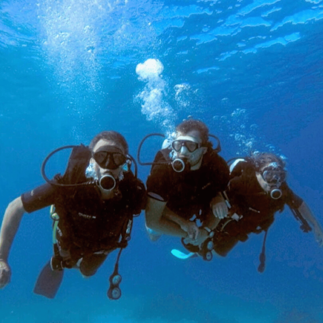 Group of friends excitedly diving in Fiji